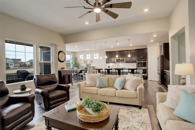 living room featuring wood-type flooring and ceiling fan