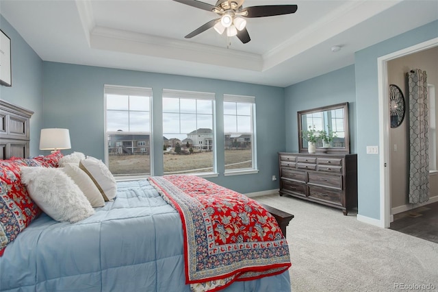 bedroom with ornamental molding, a raised ceiling, and carpet