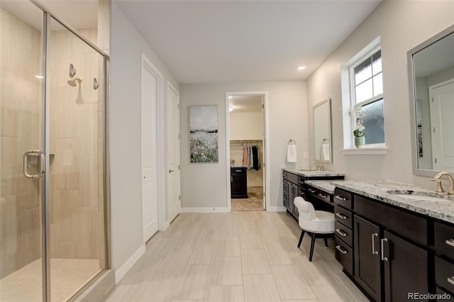 bathroom with a shower with door and vanity