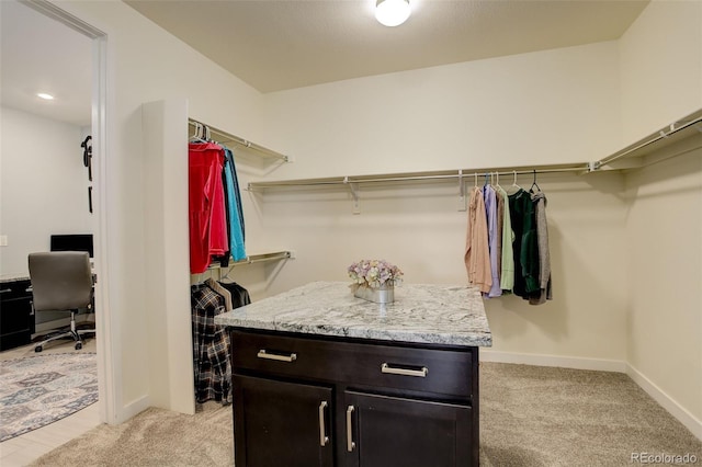 walk in closet with light carpet