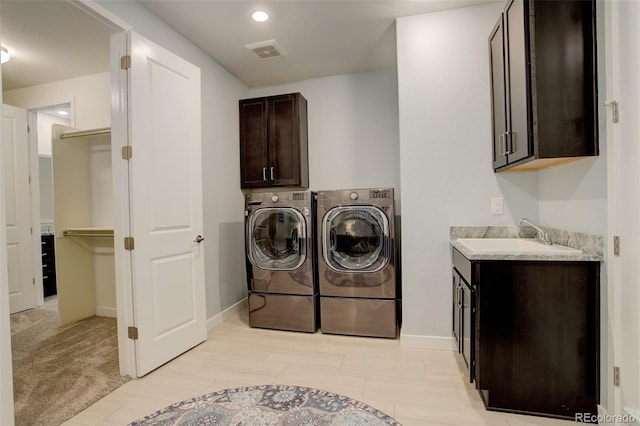 laundry area featuring cabinets, sink, and washer and clothes dryer