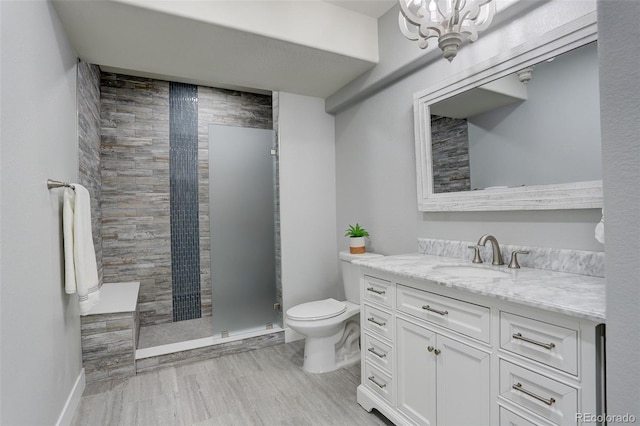 bathroom featuring vanity, toilet, and a tile shower