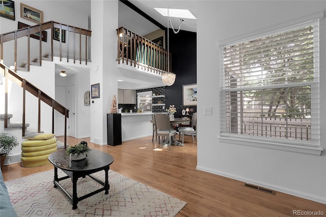 2021 S Hannibal Way Unit F, Aurora, CO 80013 - living room with stairway, wood finished floors, a skylight, and high vaulted ceiling