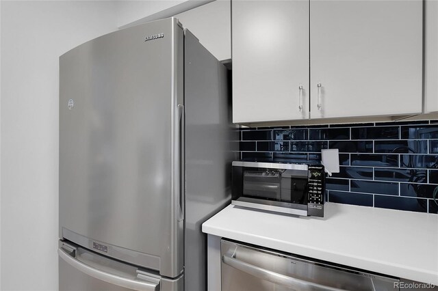 2021 S Hannibal Way Unit F, Aurora, CO 80013 - kitchen featuring appliances with stainless steel finishes, white cabinetry, backsplash, and light countertops
