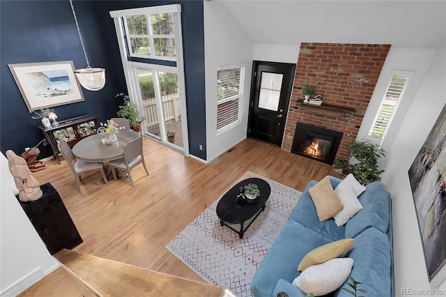 2021 S Hannibal Way Unit F, Aurora, CO 80013 - living room with wood finished floors, vaulted ceiling, and a brick fireplace
