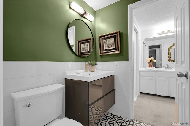 2021 S Hannibal Way Unit F, Aurora, CO 80013 - bathroom with tile walls, vanity, and a wainscoted wall