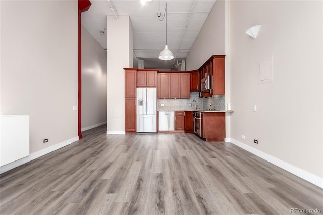 720 16th St Unit 207, Denver, CO 80202 - kitchen with stainless steel appliances, high vaulted ceiling, light countertops, backsplash, and open floor plan