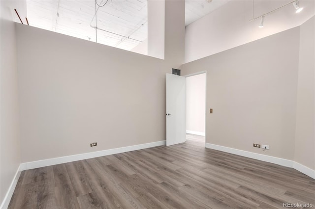 720 16th St Unit 207, Denver, CO 80202 - unfurnished room with a towering ceiling, rail lighting, and wood finished floors
