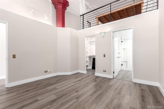 720 16th St Unit 207, Denver, CO 80202 - unfurnished room featuring ornate columns, wood finished floors, a high ceiling, and rail lighting