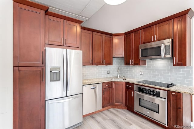 720 16th St Unit 207, Denver, CO 80202 - kitchen featuring appliances with stainless steel finishes, light wood-style floors, light stone countertops, and backsplash