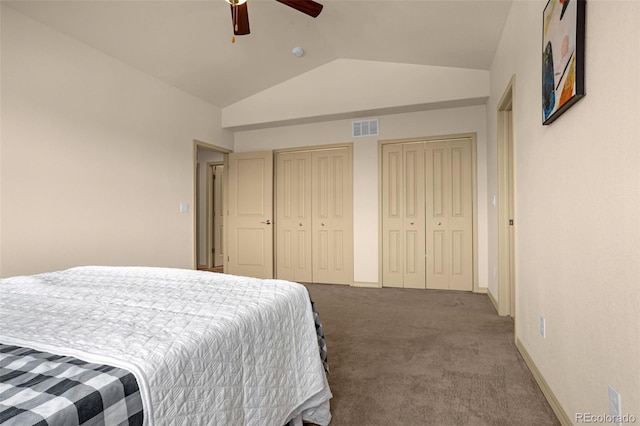 bedroom with two closets, vaulted ceiling, visible vents, carpet floors, and baseboards