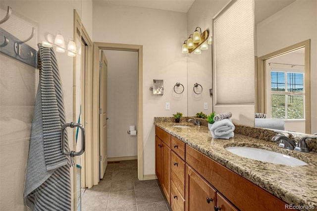 full bathroom with tile patterned floors, double vanity, baseboards, and a sink