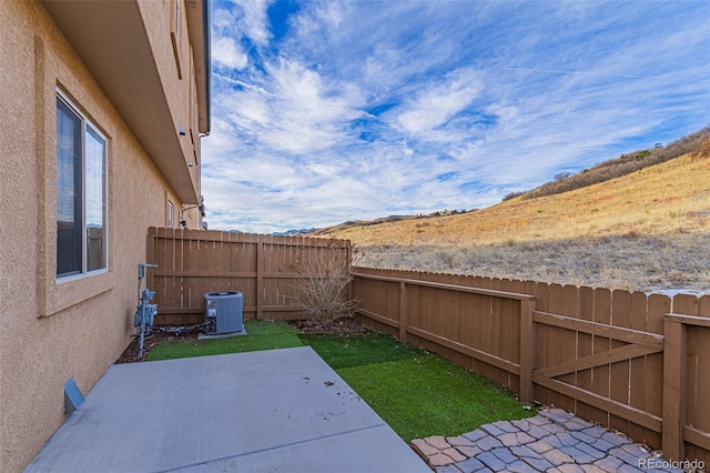 view of yard with a patio area, a fenced backyard, and central AC unit