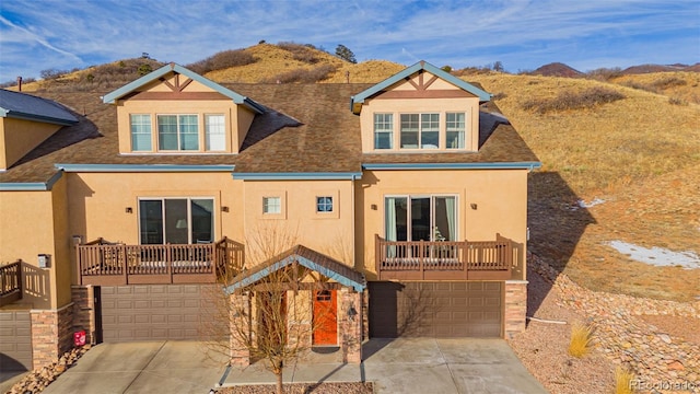 rear view of property featuring a garage, stucco siding, and driveway