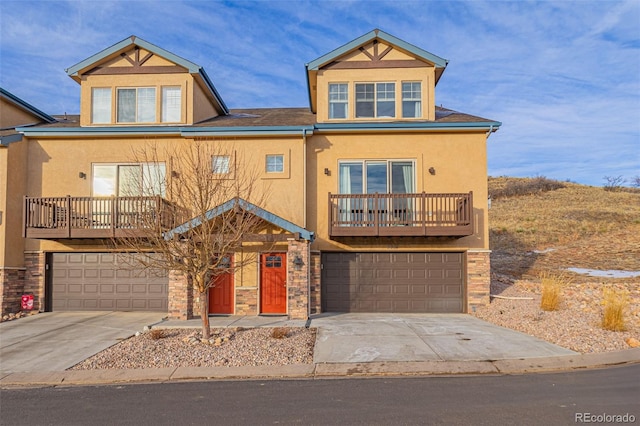 view of front of property with driveway, stone siding, a garage, and stucco siding