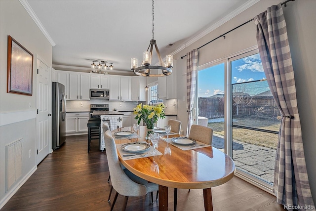 dining area with an inviting chandelier, ornamental molding, and dark hardwood / wood-style floors