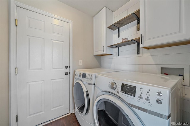 washroom with dark hardwood / wood-style floors, cabinets, and washing machine and clothes dryer