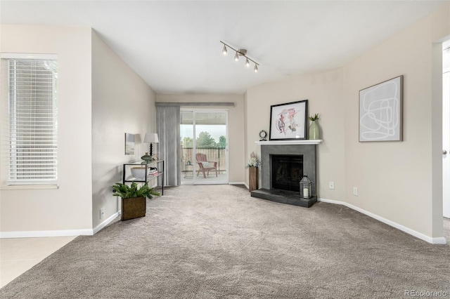 5300 E Cherry Creek S Drive 324, Denver, CO 80246 - unfurnished living room with rail lighting, carpet, and a fireplace with raised hearth