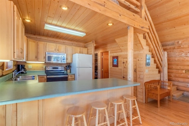 kitchen with a peninsula, appliances with stainless steel finishes, a sink, and wood ceiling