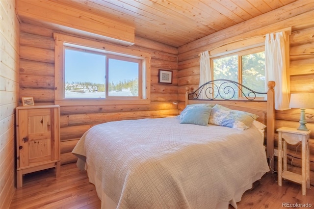 bedroom featuring log walls, wood ceiling, multiple windows, and light wood-style flooring