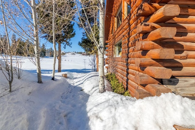 snow covered property featuring log siding