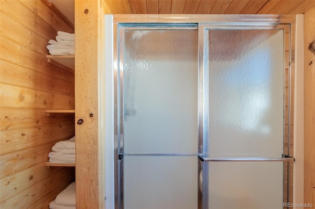 full bath with wooden ceiling, a stall shower, and wooden walls