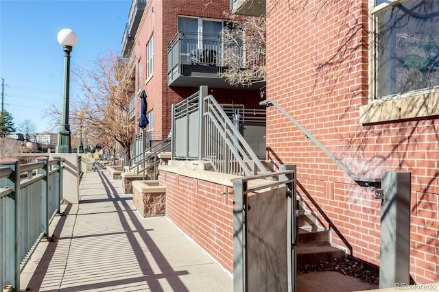 exterior space featuring brick siding and a balcony