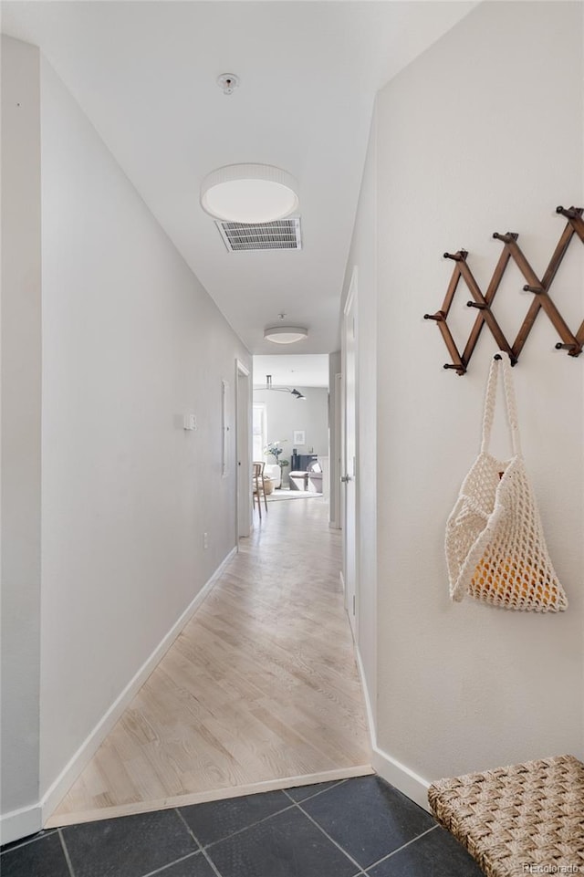 corridor with visible vents, baseboards, and wood finished floors