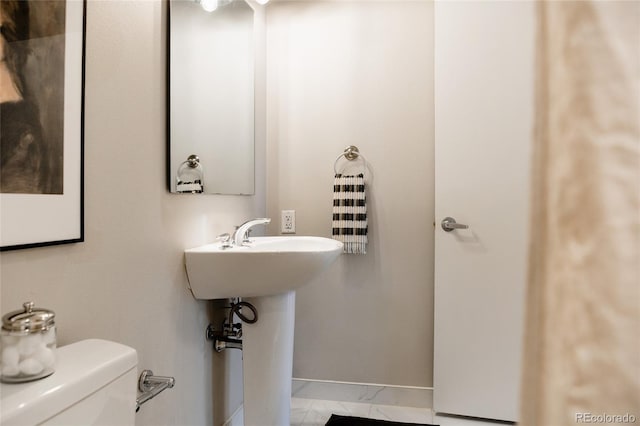 bathroom featuring baseboards and toilet