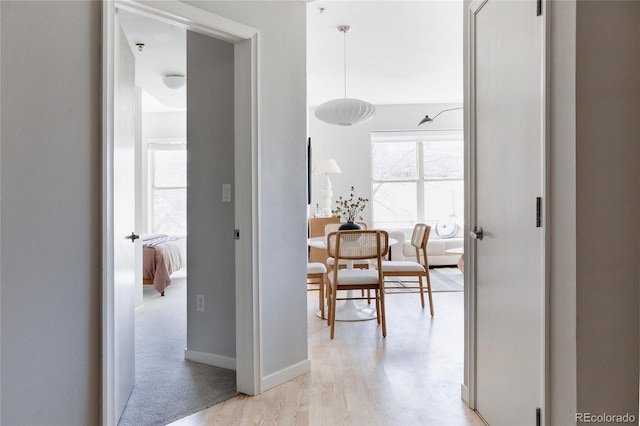 hall with light wood finished floors and baseboards