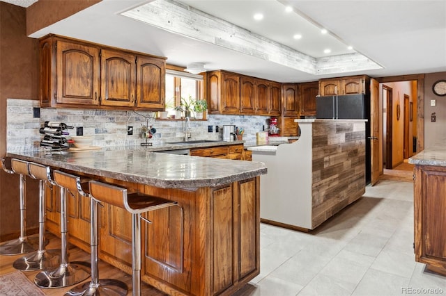 96 County Road 7, Fairplay, CO 80440 - kitchen featuring a sink, brown cabinets, backsplash, and a peninsula