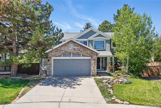 view of front facade with fence, an attached garage, stone siding, concrete driveway, and a front yard