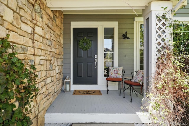 entrance to property with covered porch and stone siding