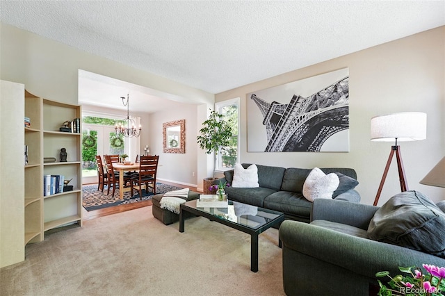 living room featuring a textured ceiling, a notable chandelier, and carpet floors