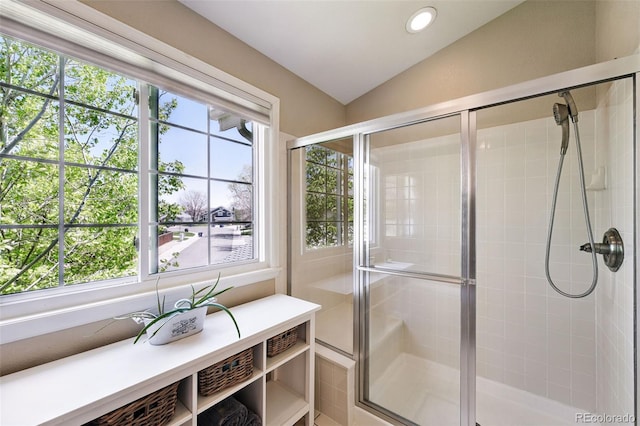 bathroom featuring a wealth of natural light, lofted ceiling, and a shower stall