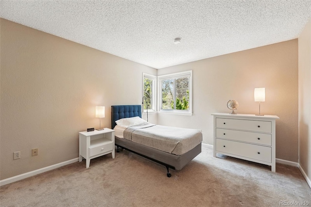 carpeted bedroom with a textured ceiling and baseboards
