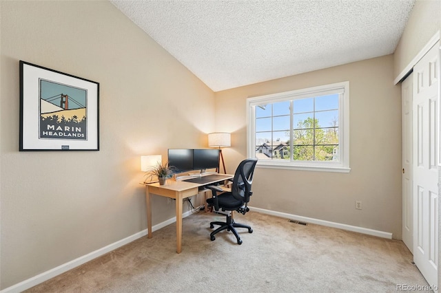 office space featuring a textured ceiling, baseboards, visible vents, vaulted ceiling, and carpet floors