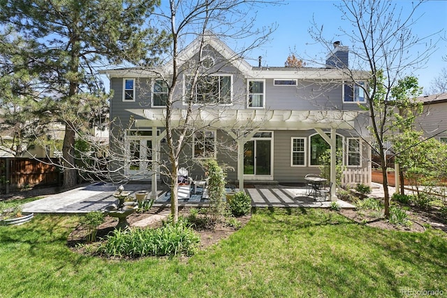 back of property featuring a yard, a patio, a chimney, and fence