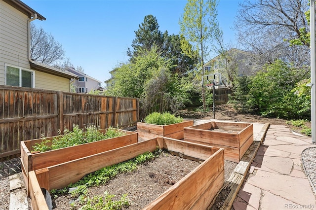 view of yard featuring fence and a vegetable garden