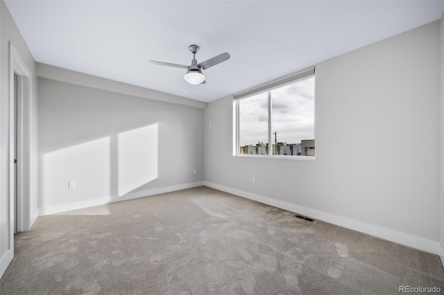 empty room featuring visible vents, carpet floors, a ceiling fan, and baseboards