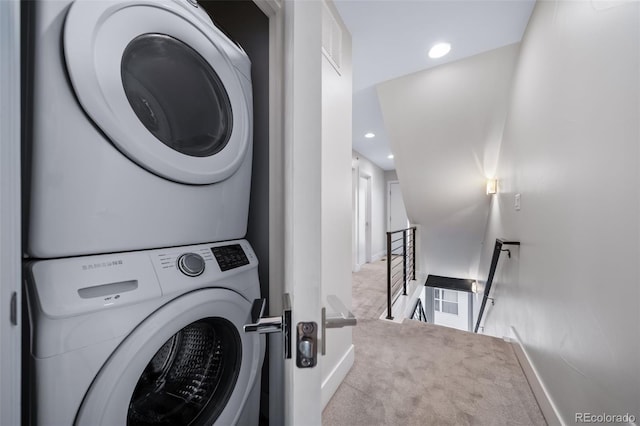 laundry room featuring laundry area, visible vents, baseboards, stacked washer and clothes dryer, and carpet floors