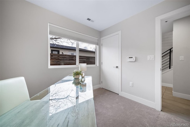 carpeted office featuring visible vents and baseboards