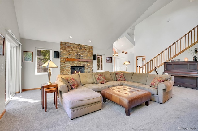 398 Mountain View Dr, Black Hawk, CO 80422 - carpeted living room with a fireplace, stairs, a chandelier, baseboards, and high vaulted ceiling