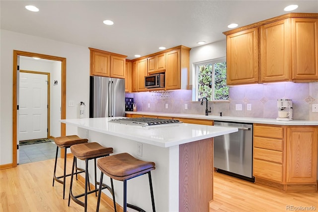 398 Mountain View Dr, Black Hawk, CO 80422 - kitchen with stainless steel appliances, a breakfast bar area, decorative backsplash, a center island, and a sink