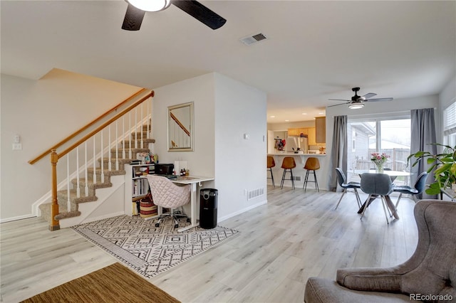 living area featuring stairs, wood finished floors, visible vents, and baseboards