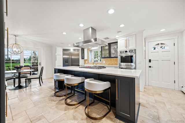 18 Club Ln, Littleton, CO 80123 - kitchen featuring island exhaust hood, stainless steel appliances, light countertops, a kitchen island, and tasteful backsplash