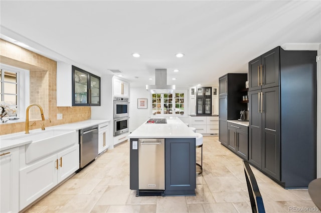 18 Club Ln, Littleton, CO 80123 - kitchen featuring a sink, backsplash, a kitchen bar, glass insert cabinets, and appliances with stainless steel finishes