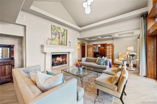 18 Club Ln, Littleton, CO 80123 - living area with high vaulted ceiling, light wood-type flooring, visible vents, arched walkways, and a lit fireplace
