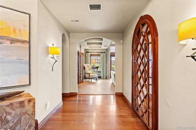 18 Club Ln, Littleton, CO 80123 - hall with arched walkways, baseboards, visible vents, and wood finished floors
