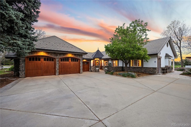 18 Club Ln, Littleton, CO 80123 - view of front facade with concrete driveway, a garage, stucco siding, and stone siding